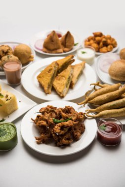 Grup Hint Çay saati aperatifler Veg Samosa, Kachori / kachaudi, aloo bonda, khaman dhokla, ekmek, soğan, biber ve moong pakora / pakoda / bhaji / bhajji / Bhajiya / soslar, seçici odak ile bajji içerir