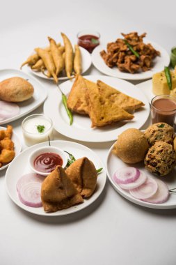 Grup Hint Çay saati aperatifler Veg Samosa, Kachori / kachaudi, aloo bonda, khaman dhokla, ekmek, soğan, biber ve moong pakora / pakoda / bhaji / bhajji / Bhajiya / soslar, seçici odak ile bajji içerir