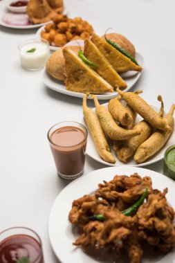 Grup Hint Çay saati aperatifler Veg Samosa, Kachori / kachaudi, aloo bonda, khaman dhokla, ekmek, soğan, biber ve moong pakora / pakoda / bhaji / bhajji / Bhajiya / soslar, seçici odak ile bajji içerir