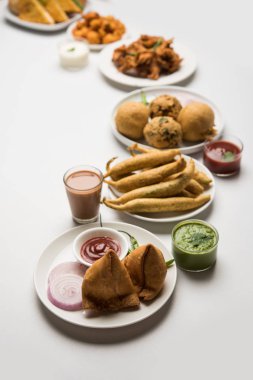 Grup Hint Çay saati aperatifler Veg Samosa, Kachori / kachaudi, aloo bonda, khaman dhokla, ekmek, soğan, biber ve moong pakora / pakoda / bhaji / bhajji / Bhajiya / soslar, seçici odak ile bajji içerir