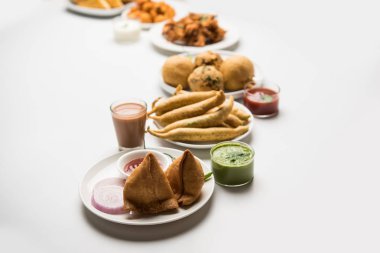 Grup Hint Çay saati aperatifler Veg Samosa, Kachori / kachaudi, aloo bonda, khaman dhokla, ekmek, soğan, biber ve moong pakora / pakoda / bhaji / bhajji / Bhajiya / soslar, seçici odak ile bajji içerir