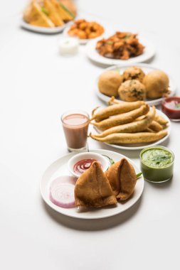 Grup Hint Çay saati aperatifler Veg Samosa, Kachori / kachaudi, aloo bonda, khaman dhokla, ekmek, soğan, biber ve moong pakora / pakoda / bhaji / bhajji / Bhajiya / soslar, seçici odak ile bajji içerir