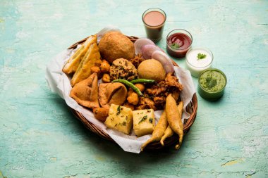 Grup Hint Çay saati aperatifler Veg Samosa, Kachori / kachaudi, aloo bonda, khaman dhokla, ekmek, soğan, biber ve moong pakora / pakoda / bhaji / bhajji / Bhajiya / soslar, seçici odak ile bajji içerir