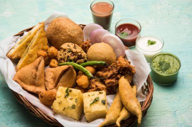 Grup Hint Çay saati aperatifler Veg Samosa, Kachori / kachaudi, aloo bonda, khaman dhokla, ekmek, soğan, biber ve moong pakora / pakoda / bhaji / bhajji / Bhajiya / soslar, seçici odak ile bajji içerir