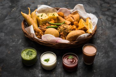 Grup Hint Çay saati aperatifler Veg Samosa, Kachori / kachaudi, aloo bonda, khaman dhokla, ekmek, soğan, biber ve moong pakora / pakoda / bhaji / bhajji / Bhajiya / soslar, seçici odak ile bajji içerir