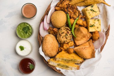 Grup Hint Çay saati aperatifler Veg Samosa, Kachori / kachaudi, aloo bonda, khaman dhokla, ekmek, soğan, biber ve moong pakora / pakoda / bhaji / bhajji / Bhajiya / soslar, seçici odak ile bajji içerir