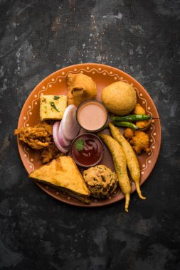 Grup Hint Çay saati aperatifler Veg Samosa, Kachori / kachaudi, aloo bonda, khaman dhokla, ekmek, soğan, biber ve moong pakora / pakoda / bhaji / bhajji / Bhajiya / soslar, seçici odak ile bajji içerir