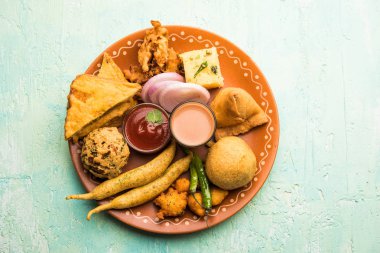 Grup Hint Çay saati aperatifler Veg Samosa, Kachori / kachaudi, aloo bonda, khaman dhokla, ekmek, soğan, biber ve moong pakora / pakoda / bhaji / bhajji / Bhajiya / soslar, seçici odak ile bajji içerir