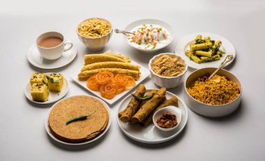 Jalebi-fafda, thepla, khaman dhokla, aloo bhujiya, khandvi, khakra, dahi vada, sıcak çay ile gathiya gibi Gujarati aperatifler Grubu