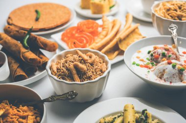 Jalebi-fafda, thepla, khaman dhokla, aloo bhujiya, khandvi, khakra, dahi vada, sıcak çay ile gathiya gibi Gujarati aperatifler Grubu