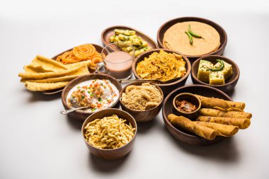 Group of Gujarati snacks like jalebi-fafda, thepla, khaman dhokla, aloo bhujiya, khandvi,khakra, dahi vada, gathiya with hot tea clipart