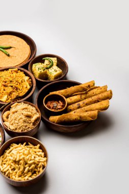 Jalebi-fafda, thepla, khaman dhokla, aloo bhujiya, khandvi, khakra, dahi vada, sıcak çay ile gathiya gibi Gujarati aperatifler Grubu