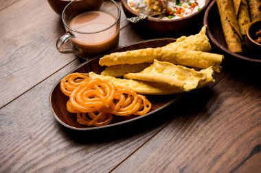 Jalebi-fafda, thepla, khaman dhokla, aloo bhujiya, khandvi, khakra, dahi vada, sıcak çay ile gathiya gibi Gujarati aperatifler Grubu