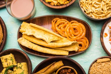 Jalebi-fafda, thepla, khaman dhokla, aloo bhujiya, khandvi, khakra, dahi vada, sıcak çay ile gathiya gibi Gujarati aperatifler Grubu