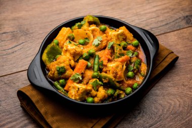 Mix sebze köri - Hint ana yemek tarifi havuç, karnabahar, yeşil bezelye ve fasulye, bebek mısır, kırmızı biber ve paneer / yazlık peynir geleneksel masala ve köri, seçici odak içerir