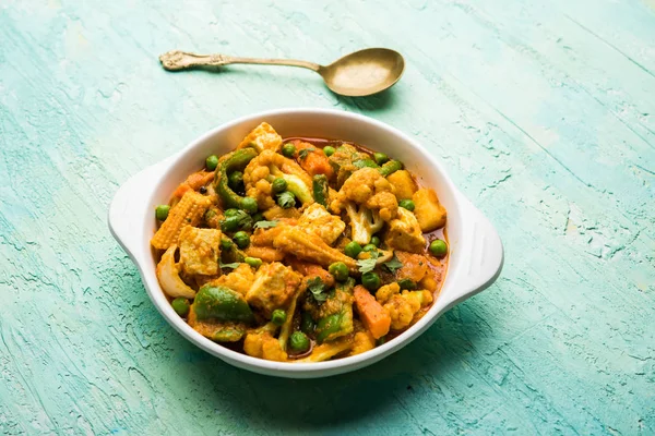 Mix vegetable curry - Indian main course recipe contains Carrots, cauliflower, green peas and beans, baby corn, capsicum and paneer/cottage cheese with traditional masala and curry, selective focus