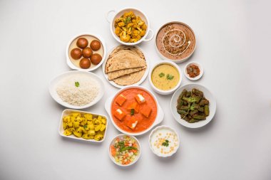 Paneer tereyağı masala, dal makhani, roti, pirinç, sabji, gulab jamun ve bağlı raita gibi çeşitli Hint gıda karamsar arka plan, seçici odak üzerinde kaselerde servis