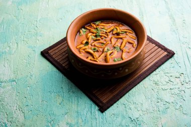 Dhaba tarzı Sev bhaji / sabzi / köri gathiya shev ile domates köri yapılan, bir kase veya karahi, seçici odak servis