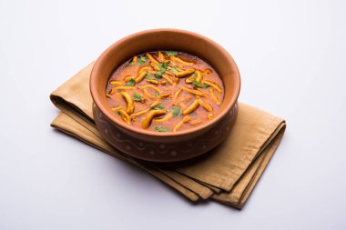 Dhaba tarzı Sev bhaji / sabzi / köri gathiya shev ile domates köri yapılan, bir kase veya karahi, seçici odak servis