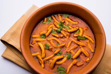 Dhaba tarzı Sev bhaji / sabzi / köri gathiya shev ile domates köri yapılan, bir kase veya karahi, seçici odak servis