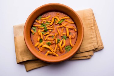 Dhaba tarzı Sev bhaji / sabzi / köri gathiya shev ile domates köri yapılan, bir kase veya karahi, seçici odak servis