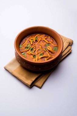 Dhaba tarzı Sev bhaji / sabzi / köri gathiya shev ile domates köri yapılan, bir kase veya karahi, seçici odak servis