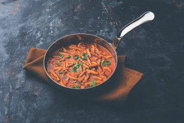 Dhaba tarzı Sev bhaji / sabzi / köri gathiya shev ile domates köri yapılan, bir kase veya karahi, seçici odak servis