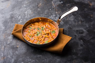 Dhaba tarzı Sev bhaji / sabzi / köri gathiya shev ile domates köri yapılan, bir kase veya karahi, seçici odak servis