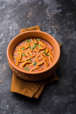 Dhaba tarzı Sev bhaji / sabzi / köri gathiya shev ile domates köri yapılan, bir kase veya karahi, seçici odak servis