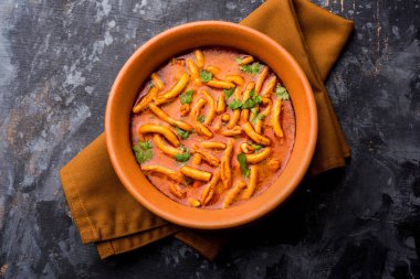 Dhaba tarzı Sev bhaji / sabzi / köri gathiya shev ile domates köri yapılan, bir kase veya karahi, seçici odak servis