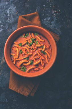 Dhaba tarzı Sev bhaji / sabzi / köri gathiya shev ile domates köri yapılan, bir kase veya karahi, seçici odak servis