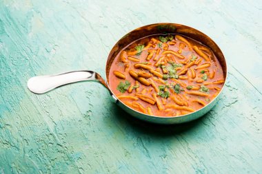 Dhaba tarzı Sev bhaji / sabzi / köri gathiya shev ile domates köri yapılan, bir kase veya karahi, seçici odak servis