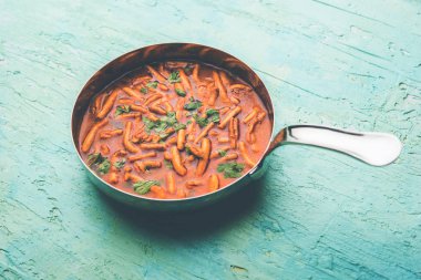 Dhaba tarzı Sev bhaji / sabzi / köri gathiya shev ile domates köri yapılan, bir kase veya karahi, seçici odak servis