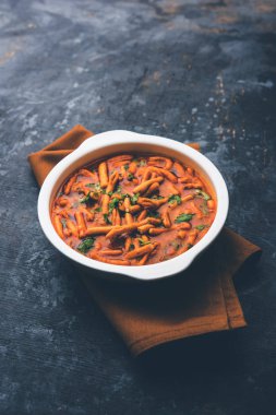 Dhaba tarzı Sev bhaji / sabzi / köri gathiya shev ile domates köri yapılan, bir kase veya karahi, seçici odak servis