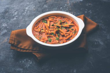 Dhaba tarzı Sev bhaji / sabzi / köri gathiya shev ile domates köri yapılan, bir kase veya karahi, seçici odak servis