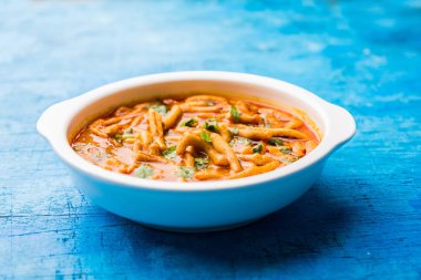 Dhaba tarzı Sev bhaji / sabzi / köri gathiya shev ile domates köri yapılan, bir kase veya karahi, seçici odak servis