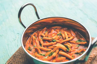 Dhaba tarzı Sev bhaji / sabzi / köri gathiya shev ile domates köri yapılan, bir kase veya karahi, seçici odak servis