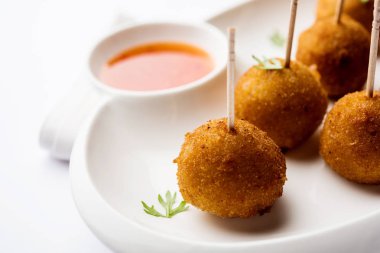 Gevrek Sebze lolipop tarifi mısır unu ve ekmek kırıntıları kaplama ile kaplı baharat ile haşlanmış patates kullanılarak yapılan ve daha sonra derin kızarmış, kürdan veya dondurma stok sos ile eklenen ile servis