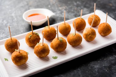 Gevrek Sebze lolipop tarifi mısır unu ve ekmek kırıntıları kaplama ile kaplı baharat ile haşlanmış patates kullanılarak yapılan ve daha sonra derin kızarmış, kürdan veya dondurma stok sos ile eklenen ile servis