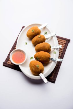 Gevrek Sebze lolipop tarifi mısır unu ve ekmek kırıntıları kaplama ile kaplı baharat ile haşlanmış patates kullanılarak yapılan ve daha sonra derin kızarmış, kürdan veya dondurma stok sos ile eklenen ile servis