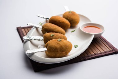 Gevrek Sebze lolipop tarifi mısır unu ve ekmek kırıntıları kaplama ile kaplı baharat ile haşlanmış patates kullanılarak yapılan ve daha sonra derin kızarmış, kürdan veya dondurma stok sos ile eklenen ile servis