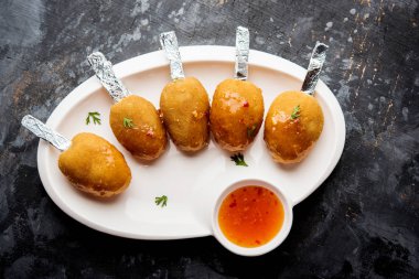 Gevrek Sebze lolipop tarifi mısır unu ve ekmek kırıntıları kaplama ile kaplı baharat ile haşlanmış patates kullanılarak yapılan ve daha sonra derin kızarmış, kürdan veya dondurma stok sos ile eklenen ile servis