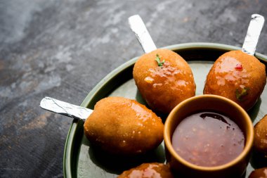 Gevrek Sebze lolipop tarifi mısır unu ve ekmek kırıntıları kaplama ile kaplı baharat ile haşlanmış patates kullanılarak yapılan ve daha sonra derin kızarmış, kürdan veya dondurma stok sos ile eklenen ile servis