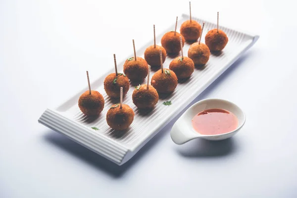 Crispy Veg lollipop recipe made using boiled potato with spices covered with corn flour and bread crumbs coating and then deep fried, served with toothpick or ice cream stock inserted in it with sauce