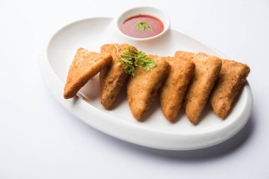 gevrek Patates üçgenveya batata vada ekmek kırıntıları ile kaplı ve daha sonra derin kızarmış. domates ketçap ile servis edilir. seçici odaklama