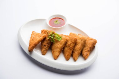 gevrek Patates üçgenveya batata vada ekmek kırıntıları ile kaplı ve daha sonra derin kızarmış. domates ketçap ile servis edilir. seçici odaklama