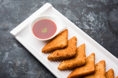 gevrek Patates üçgenveya batata vada ekmek kırıntıları ile kaplı ve daha sonra derin kızarmış. domates ketçap ile servis edilir. seçici odaklama