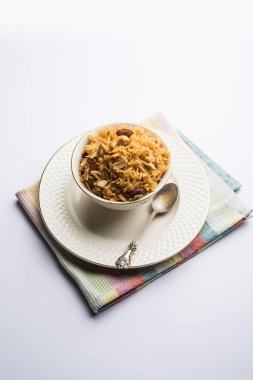 Hintçe Geleneksel Jaggery Pirinç veya Gur wale chawal, kaşıkla bir kase servis. seçici odaklama