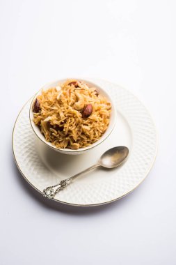 Hintçe Geleneksel Jaggery Pirinç veya Gur wale chawal, kaşıkla bir kase servis. seçici odaklama