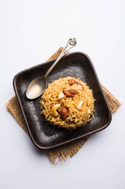 Hintçe Geleneksel Jaggery Pirinç veya Gur wale chawal, kaşıkla bir kase servis. seçici odaklama